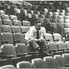 Elia Kazan sitting on top of theatre seats (wide).