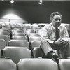 Elia Kazan sitting on top of theatre seats (close-up).