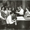Stephen Sondheim on piano with Leonard Bernstein and Carol Lawrence (on far right) standing amongst female singers rehearsing for the stage production West Side Story.