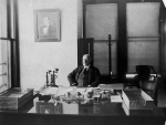 William Williams at his desk [front view]