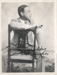 Autographed photo of William Grant Still seated in holding a cigar.