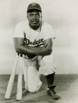 Jackie Robinson kneeling with two baseball bats