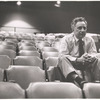 Elia Kazan sitting alone in an empty auditorium.