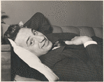 Elia Kazan smiling and lying on sofa.