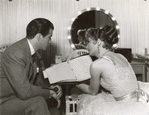 Robert Taylor and Barbara Stanwyck backstage in dressing room on the set of the motion picture This Is My Affair