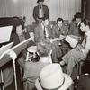 Robert Taylor, producer Ed Gardner, Writer Morton Harris, and cast members during rehearsals for an episode of the NBC radio program Good News of 1938