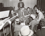 Robert Taylor, producer Ed Gardner, Writer Morton Harris, and cast members during rehearsals for an episode of the NBC radio program Good News of 1938
