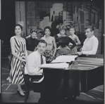 Carol Lawrence, Stephen Sondheim, Leonard Bernstein and unidentified cast members around the piano rehearsing for West Side Story.