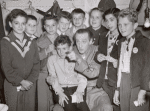 Basil Rathbone (center) surrounded by group of unidentified boys backstage during run of the stage production Sherlock Holmes