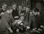 Paul Henveid, Robert Donat, and others surrounding Greer Garson in the motion picture Goodbye, Mr. Chips