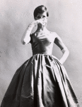 Unidentified model wearing Norman Norell sleeveless satin evening gown and long white opera gloves