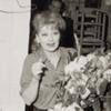 Lucille Ball holding flowers on opening night of Wildcat.
