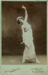 Thamara de Svirsky standing in fourth position, facing sideways, upper torso twisted towards front