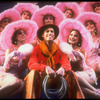 Actor Keith Carradine surrounded by beautiful dancing girls in scene fromBroadway show "The Will Rogers Follies.