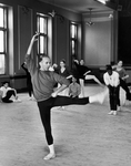 Choreographer Jerome Robbins demonstrating a move while smoking as ballet dancers look on.