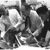 New York City Ballet rehearsal room, unidentified dancer, Jerome Robbins, George Balanchine and costumer Barbara Karinska looking at Nicholas Benois' sketches for "Theme and variations", choreography by George Balanchine (New York)