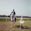 New York City Ballet - dancer Suzanne Farrell poses on race track with horse and rider (dressage), publicity photo for opening of new theatre at Saratoga Performing Arts Center (Saratoga)