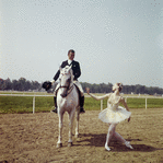 New York City Ballet - dancer Suzanne Farrell poses on race track with horse and rider (dressage), publicity photo for opening of new theatre at Saratoga Performing Arts Center (Saratoga)