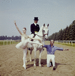 New York City Ballet - dancer Suzanne Farrell poses with George Balanchine on race track with horse and rider (dressage), publicity photo for opening of new theatre at Saratoga Performing Arts Center (Saratoga)