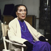 Portrait of choreographer Martha Graham sitting in front of mirror in rehearsal room