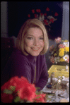 Actress Ellen Burstyn sitting at vanity table between 2 bouquets of flowers