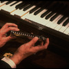 Hands of musician Larry Adler holding a harmonica. (New York)