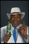 Publicity photo of designer/director/choreographer/actor Geoffrey Holder holding bottle of 7up (New York)