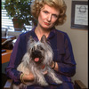 Publicity photo of theater producer Nell Nugent posing with pet dog (New York)