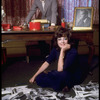 Opera singer Anna Moffo looking through publicity photos scattered on the floor at home with her husband Mario Lanfranchi behind desk in the study of their eastside brownstone (New York)