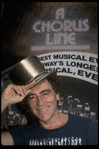 Producer Joseph Papp posing with top hat from "A Chorus Line" on occasion of its becoming the longest running Broadway musical (New York)