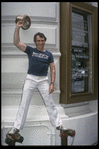 Producer Joseph Papp posing in front of Shubert Theatre with top hat from "A Chorus Line" on occasion of it becoming the longest running Broadway musical (New York)