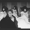 Actor Raul Julia with three dancers in bkgrd. in a scene from the Broadway production of the musical "Nine".