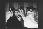 Actor Raul Julia with three dancers in bkgrd. in a scene from the Broadway production of the musical "Nine".
