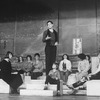 Actor Raul Julia conducting an orchestra of the women in his life incl. Karen Akers (2L) and Anita Morris (L) during a rehearsal for the Broadway production of the musical "Nine.".
