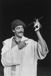Actor Raul Julia holding a toy helicopter in a scene from the NY Shakespeare Festival Central Park production of the play "The Tempest."