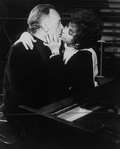 Actors Elizabeth Taylor and Richard Burton about to kiss while rehearsing a scene from the Broadway revival of the play "Private LIves".