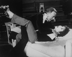 Actors Elizabeth Taylor and Richard Burton strangling each other while rehearsing a scene from the Broadway revival of the play "Private Lives".