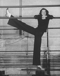 Director/choreographer Tommy Tune extending his long leg on a barre.