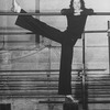 Director/choreographer Tommy Tune extending his long leg on a barre.