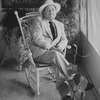 Playwright Tennessee Williams sitting in an ornate rocking chair