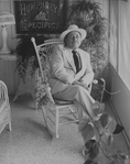 Playwright Tennessee Williams sitting in an ornate rocking chair