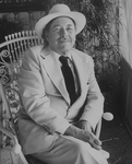 Playwright Tennessee Williams sitting in an ornate rocking chair