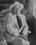 Playwright Tennessee Williams sitting in an ornate rocking chair