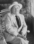 Playwright Tennessee Williams sitting in an ornate rocking chair