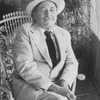 Playwright Tennessee Williams sitting in an ornate rocking chair