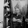 Sculptor Isamu Noguchi standing amidst his works in his studio.