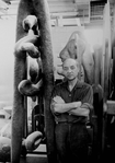 Sculptor Isamu Noguchi standing amidst his works in his studio.