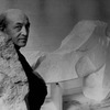 Sculptor Isamu Noguchi standing amidst his works in his studio.