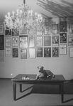 Sandy the dog lying on a table next to a chess set in the lobby of the Alvin Theatre where he performs in the Broadway production of the musical "Annie.".