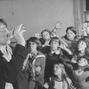 Actress Dorothy Loudon having a drink as she is surrounded by orphan girls incl. Andrea McArdle (2L) as Little Orphan Annie during a rehearsal for the Broadway production of the musical "Annie.".